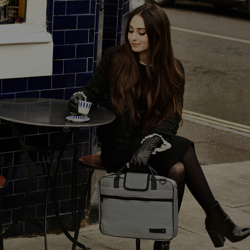 girl sat at cafe with pin stripe music bag